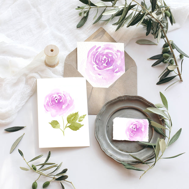 Decorative setting with floral cards and olive branches on a white surface
