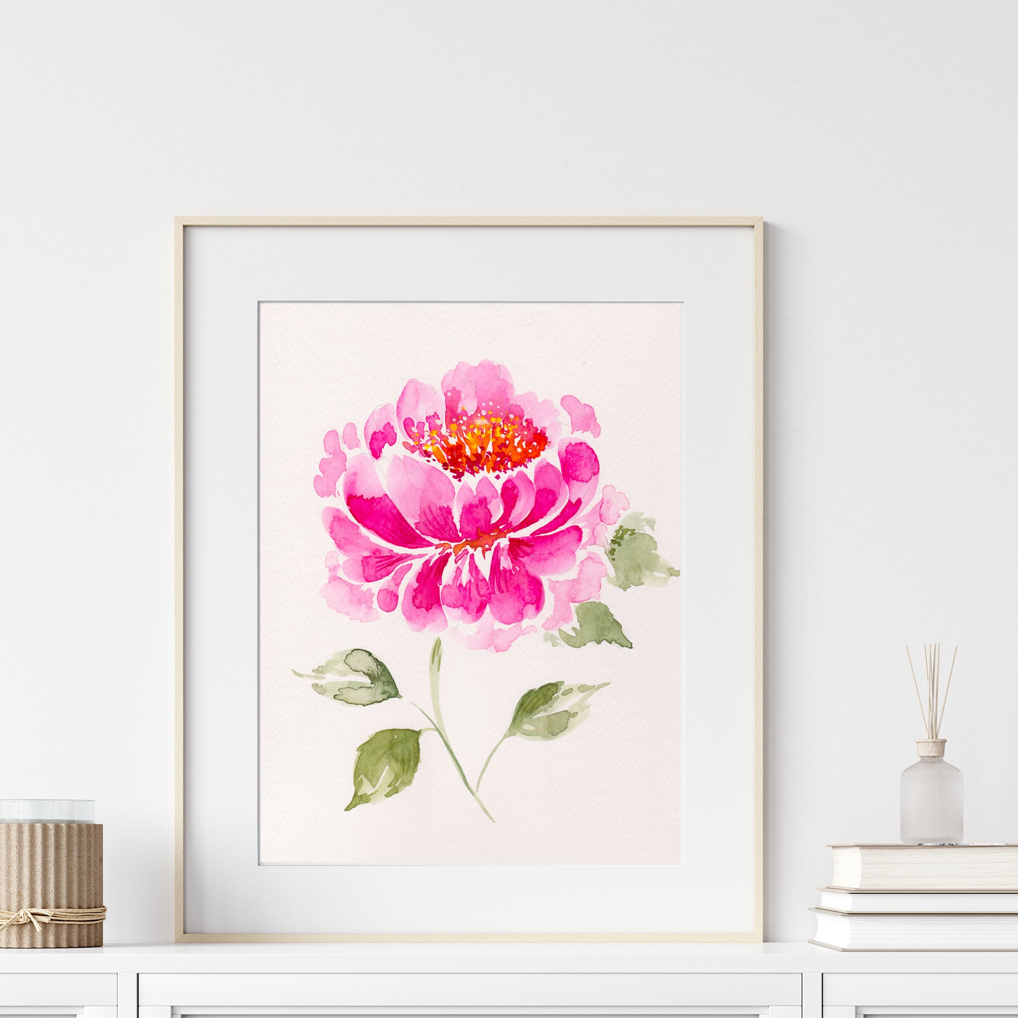 Framed artwork of a pink flower on a white wall