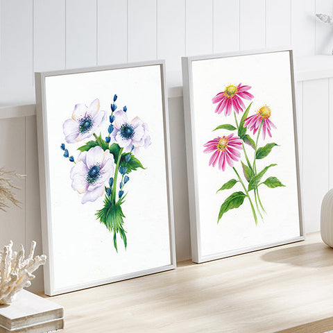 Two Flower Paintings Side by Side in a brightly lit room on a desk