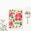 Floral painting with pink and orange flowers on a white wall, with a plant and pot in the background.