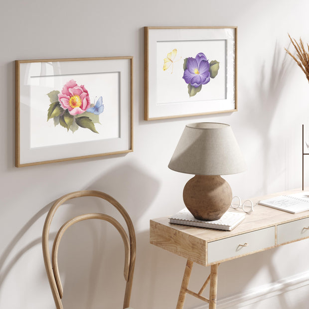 Home office with floral framed art, a lamp, and a chair.